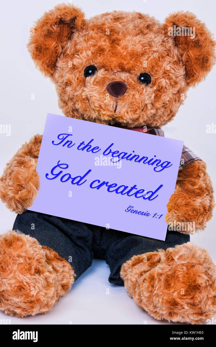 Mignon ours en peluche tenant un panneau avec pourpre au commencement Dieu créa isolé sur fond blanc Banque D'Images