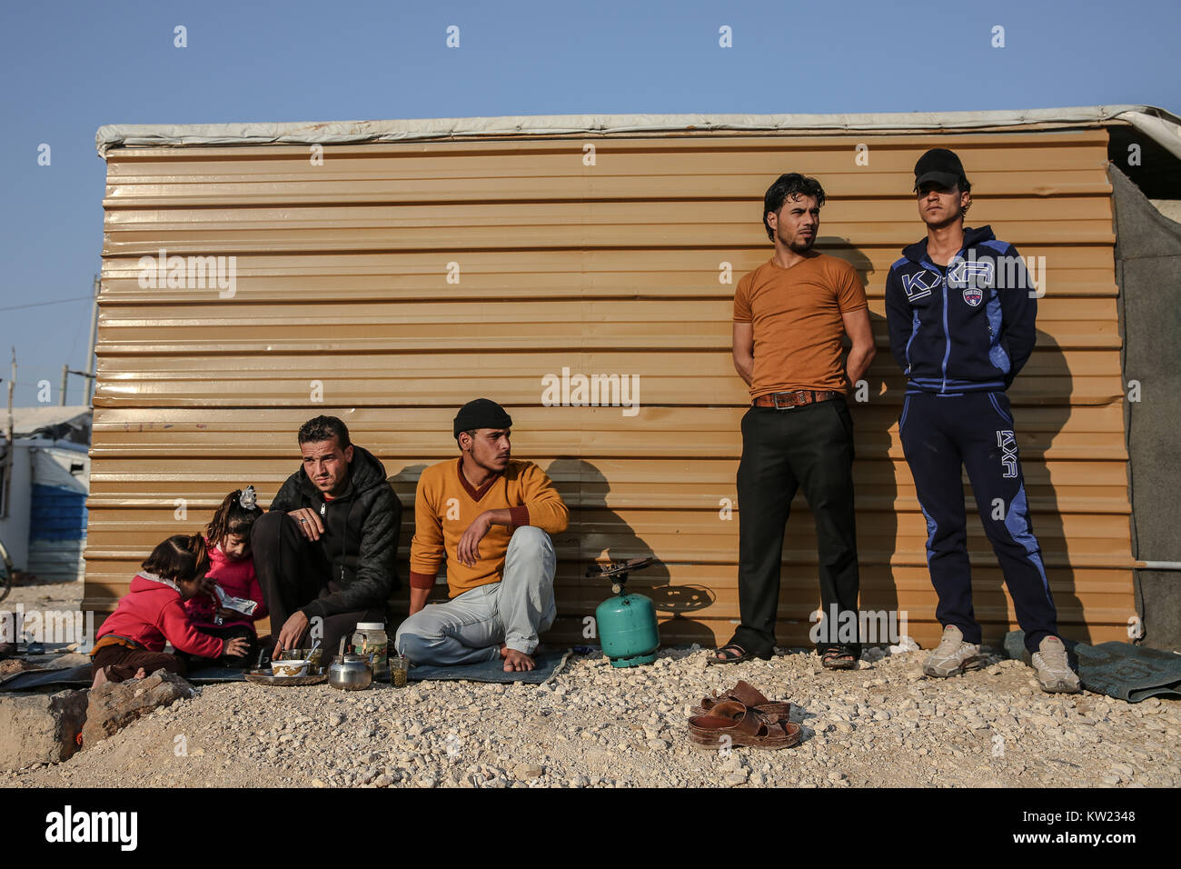 La Jordanie. 21 Jan, 2017. Les hommes et les enfants d'attendre par un abri dans le camp de réfugiés de Zaatari, le plus grand camp de réfugiés syriens, qui a ouvert ses portes en 2012. Il est en train de devenir progressivement un règlement permanent.Il n'y a actuellement plus de 700 000 réfugiés syriens en Jordanie s'échappant de la conflit de la nation d'accueil qui a commencé depuis 2011. Credit : Sally Hayden/SOPA/ZUMA/Alamy Fil Live News Banque D'Images