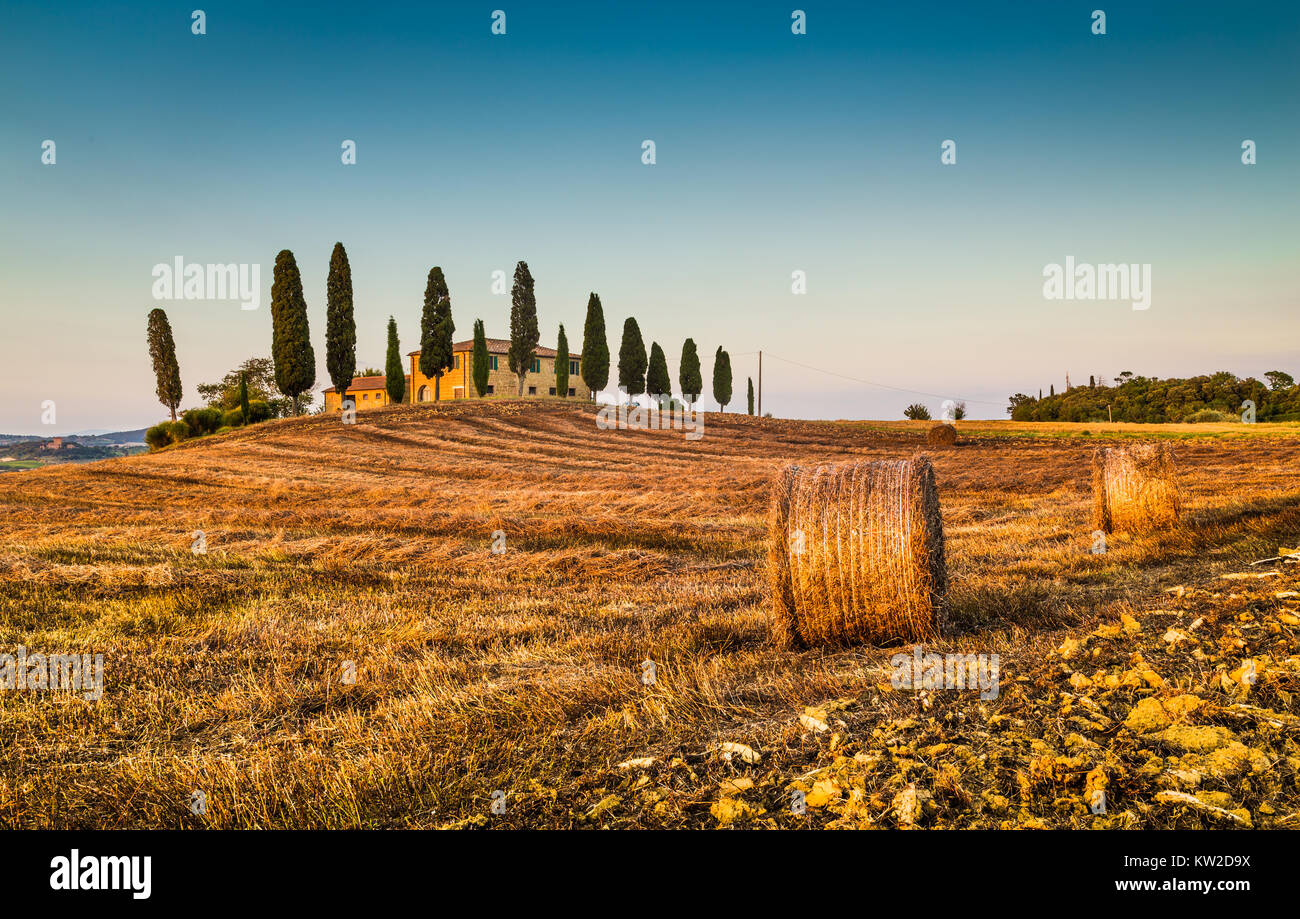 Beau paysage Toscane traditionnelle avec maison de ferme et bottes de foin dans la lumière du soir d'or, Val d'Orcia, Italie Banque D'Images
