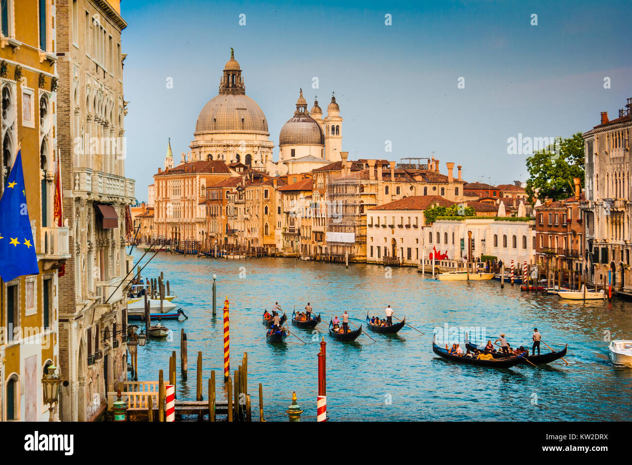 Belle vue de gondoles sur célèbre Canal Grande avec la Basilique Santa Maria della Salute au coucher du soleil à Venise, Italie Banque D'Images