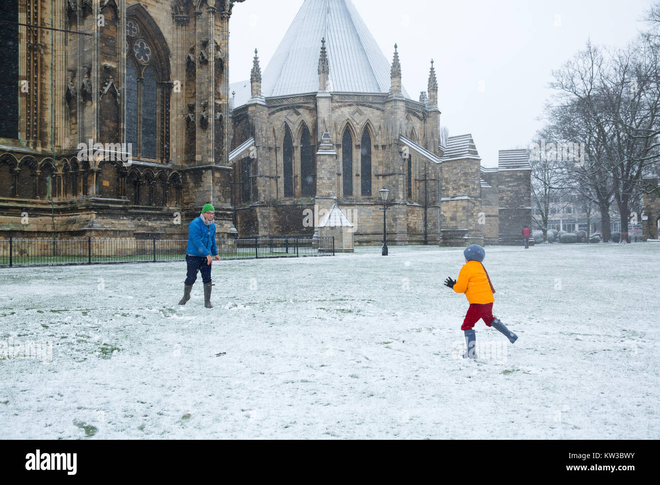 Deux personnes ayant une bataille de boules de neige dans le parc de la cathédrale de Lincoln sur une nuit de chute de neige Banque D'Images