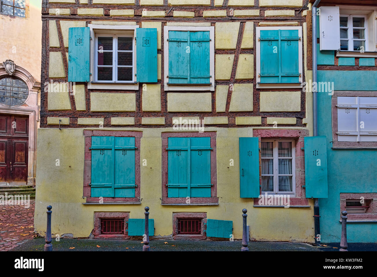 Fenêtres bleues sur les murs jaune pâle d'une petite ville Banque D'Images