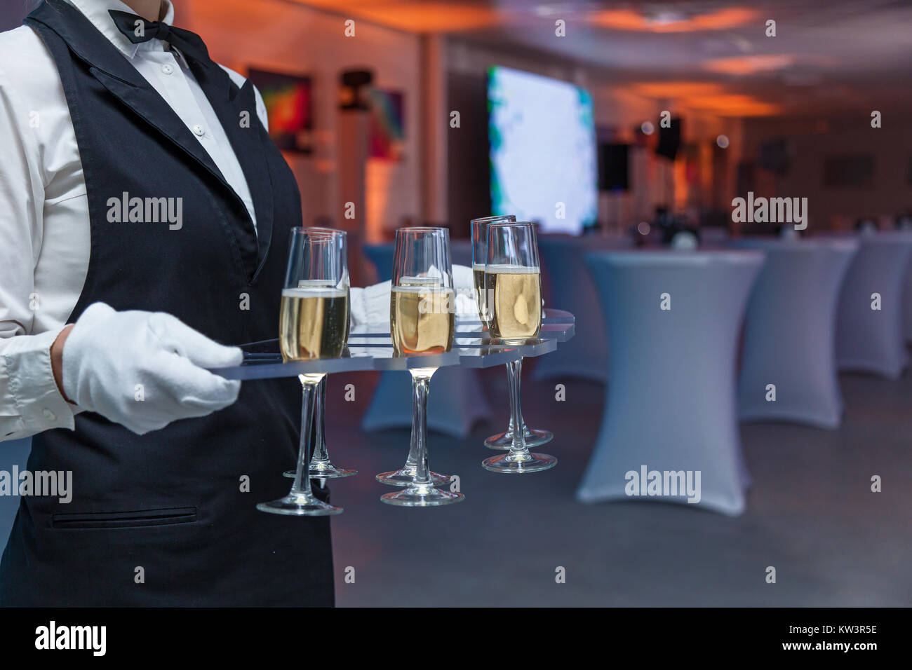 Le serveur contient des verres avec champagne sur un plateau Banque D'Images