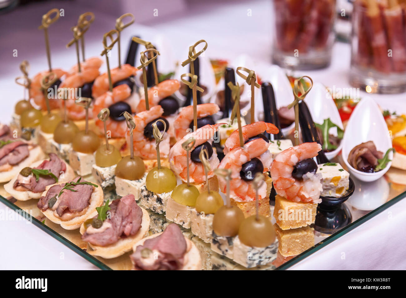 Crevettes aux olives, fromage avec des raisins et des canapés avec de la viande. Cocktail d'accueil Banque D'Images