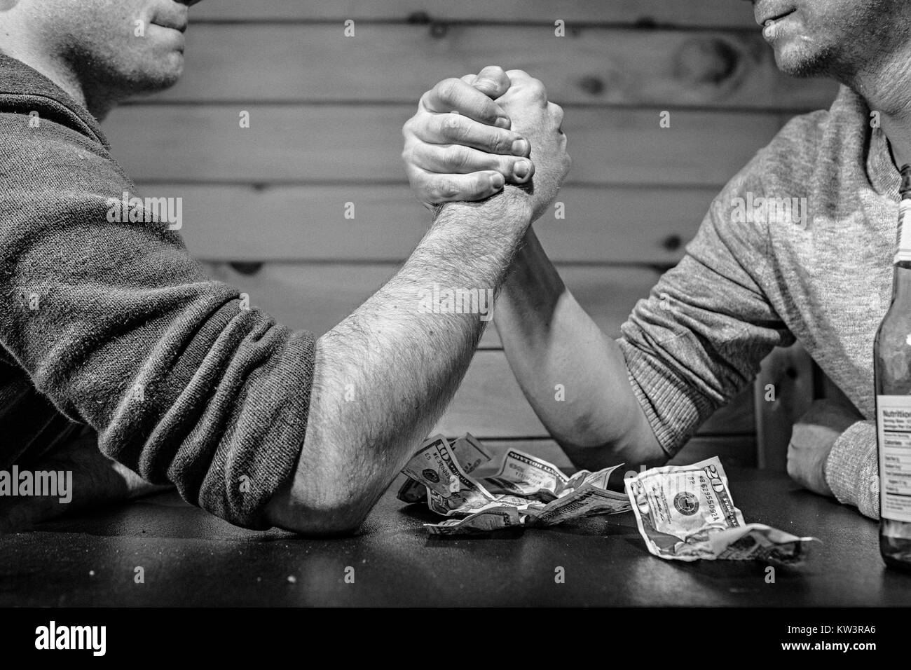 L'image capture une photographie en noir et blanc d'hommes dans un bar. La scène offre un aperçu historique de la vie sociale et des interactions, en se concentrant sur l'atmosphère d'un bar dans une période donnée. Cette photographie est le reflet de la dynamique sociale et du contexte culturel de l’époque. Banque D'Images