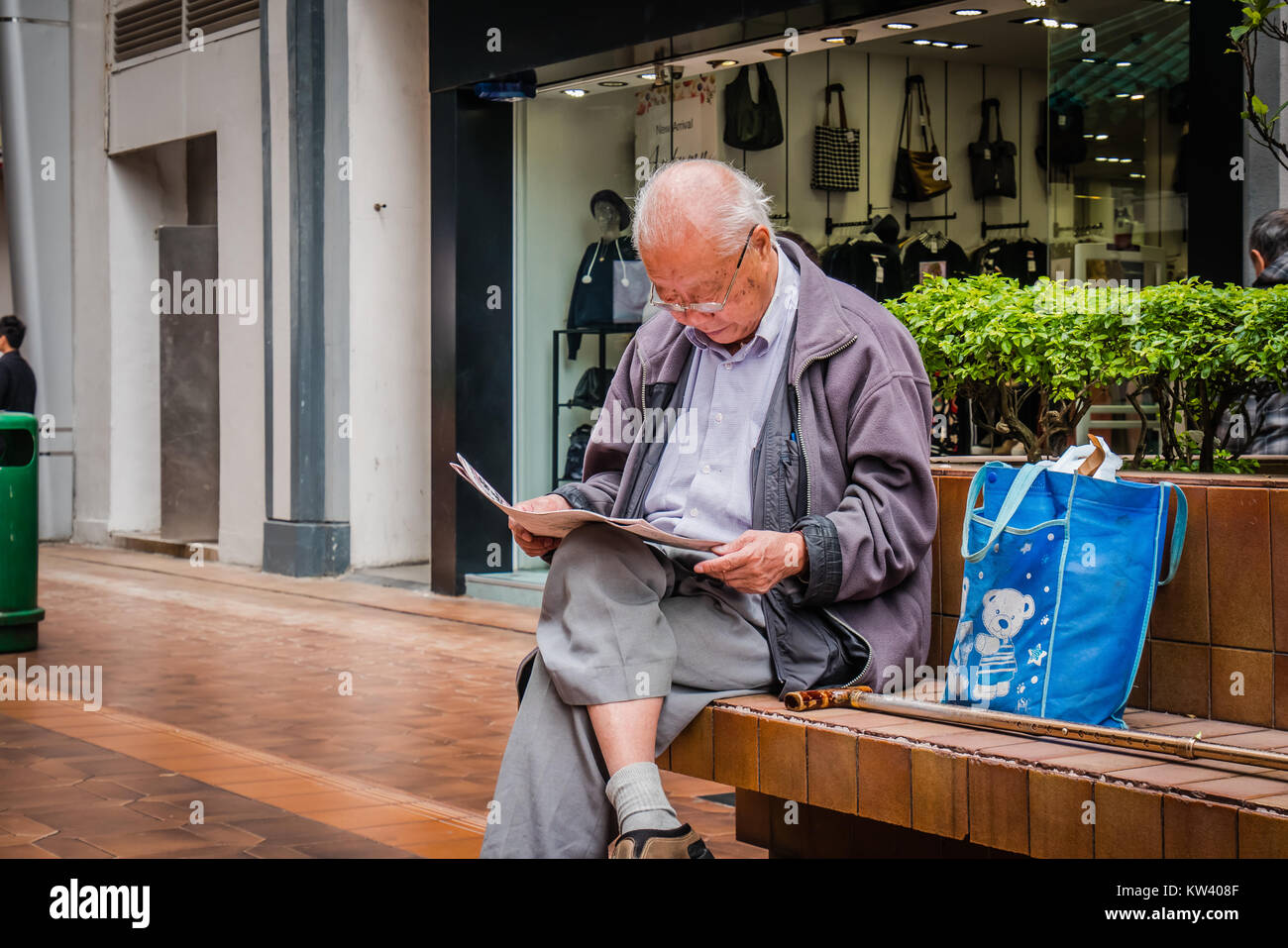 Old chinese man reading newspaper Banque D'Images