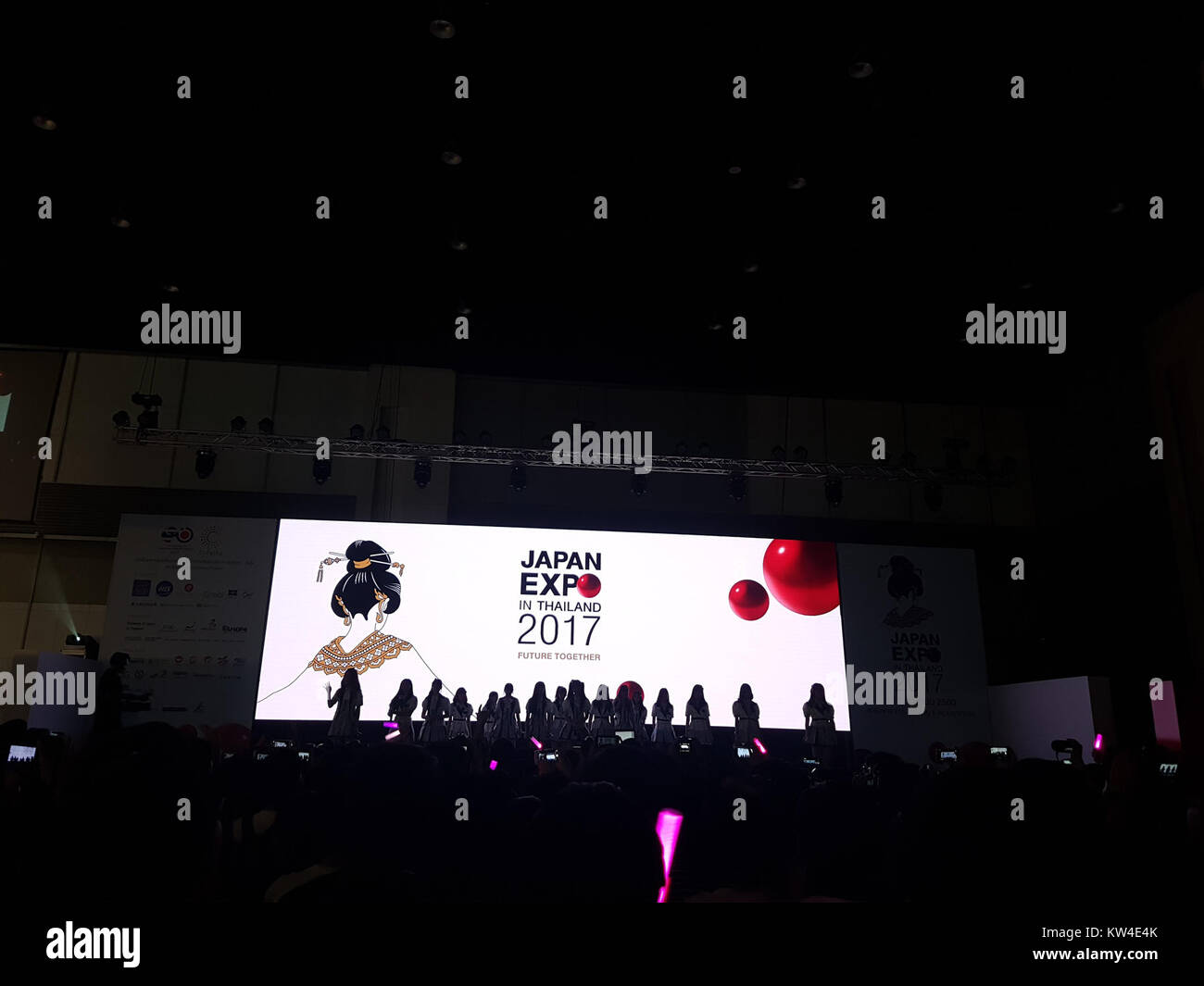 Cette image de la Japan Expo de Bangkok, 2017, montre la performance de BNK48, un groupe d'idoles thaïlandais populaire. Le groupe est connu pour ses performances énergiques et sa forte base de fans en Thaïlande. Banque D'Images
