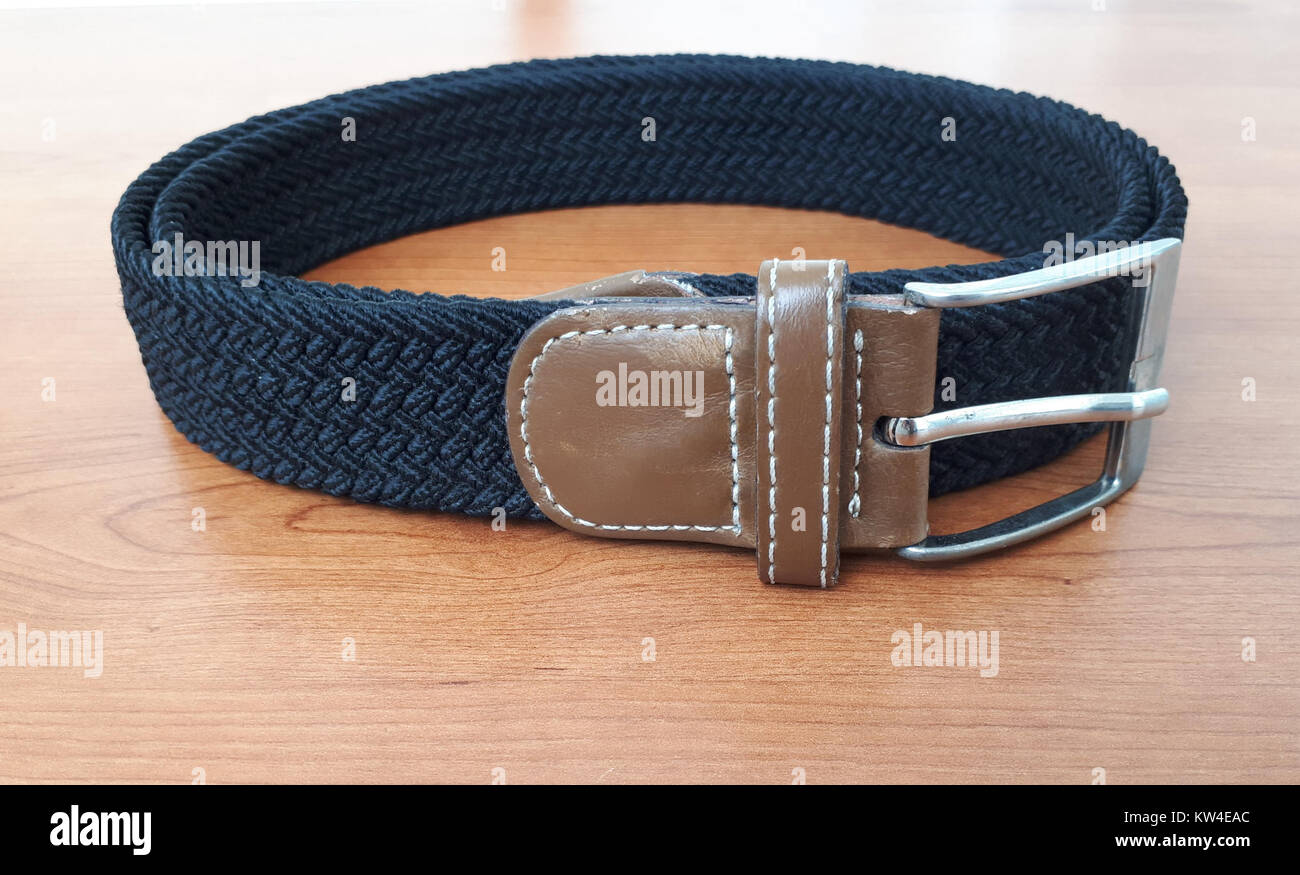 Cette ceinture noire en polyester tissé extensible présente une chape marron, alliant des éléments fonctionnels et tendance. Il convient à un usage quotidien, offrant à la fois confort et style. Banque D'Images