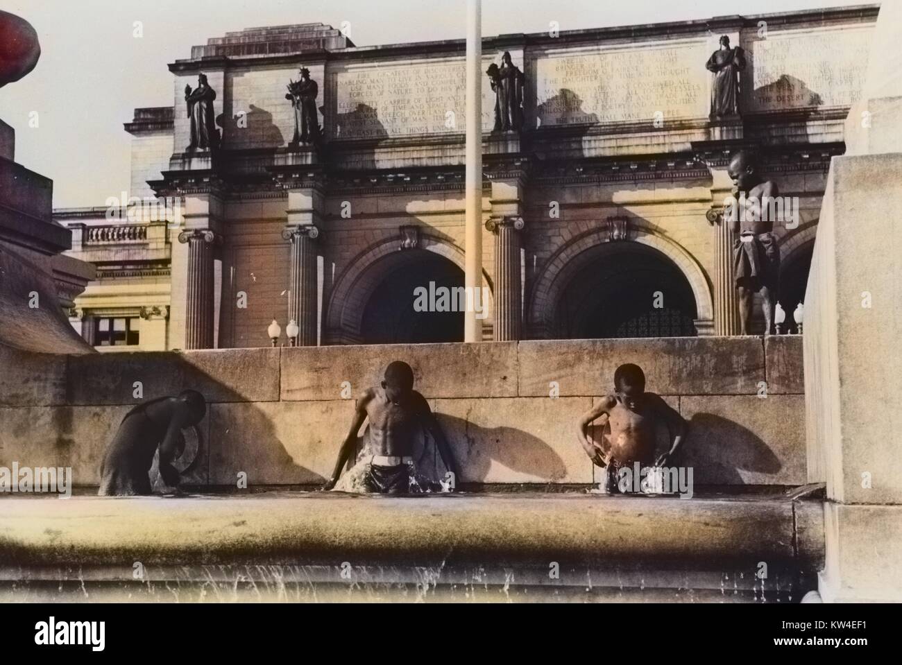 Les jeunes Afro-américains la natation dans l'ensemble de la fontaine de la gare Union, Washington, DC, 1938. À partir de la Bibliothèque publique de New York. Remarque : l'image a été colorisée numériquement à l'aide d'un processus moderne. Les couleurs peuvent ne pas être exacts à l'autre. Banque D'Images