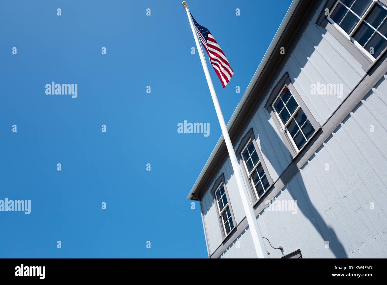 Un drapeau américain vole au-dessus de la ligne de chemin de fer et la Gare Maritime Museum de Tiburon, Californie, 2016. Banque D'Images