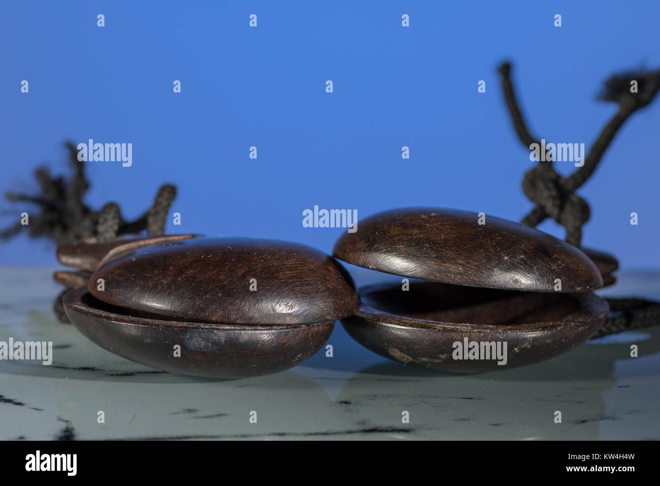 Deux Castagnettes espagnoles en bois brun foncé en face de fond bleu Banque D'Images