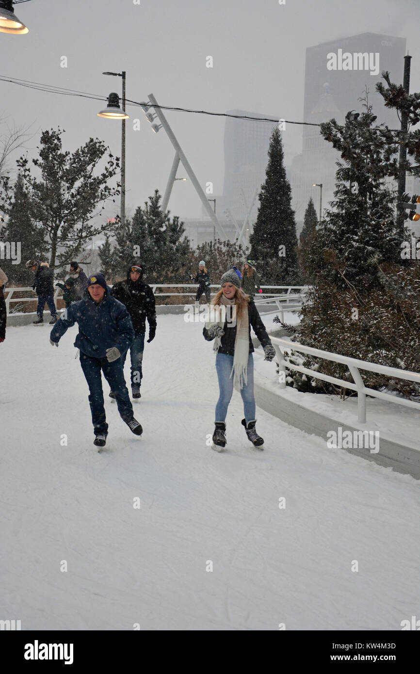 Un couple aime le patin à glace dans la neige au ruban de patinage, un sentier sinueux le long du lac à Chicago's Maggie Daley Park. Banque D'Images Un couple aime le patin à glace dans la neige au ruban de patinage, un sentier sinueux le long du lac à Chicago's Maggie Daley Park. Banque D'Images