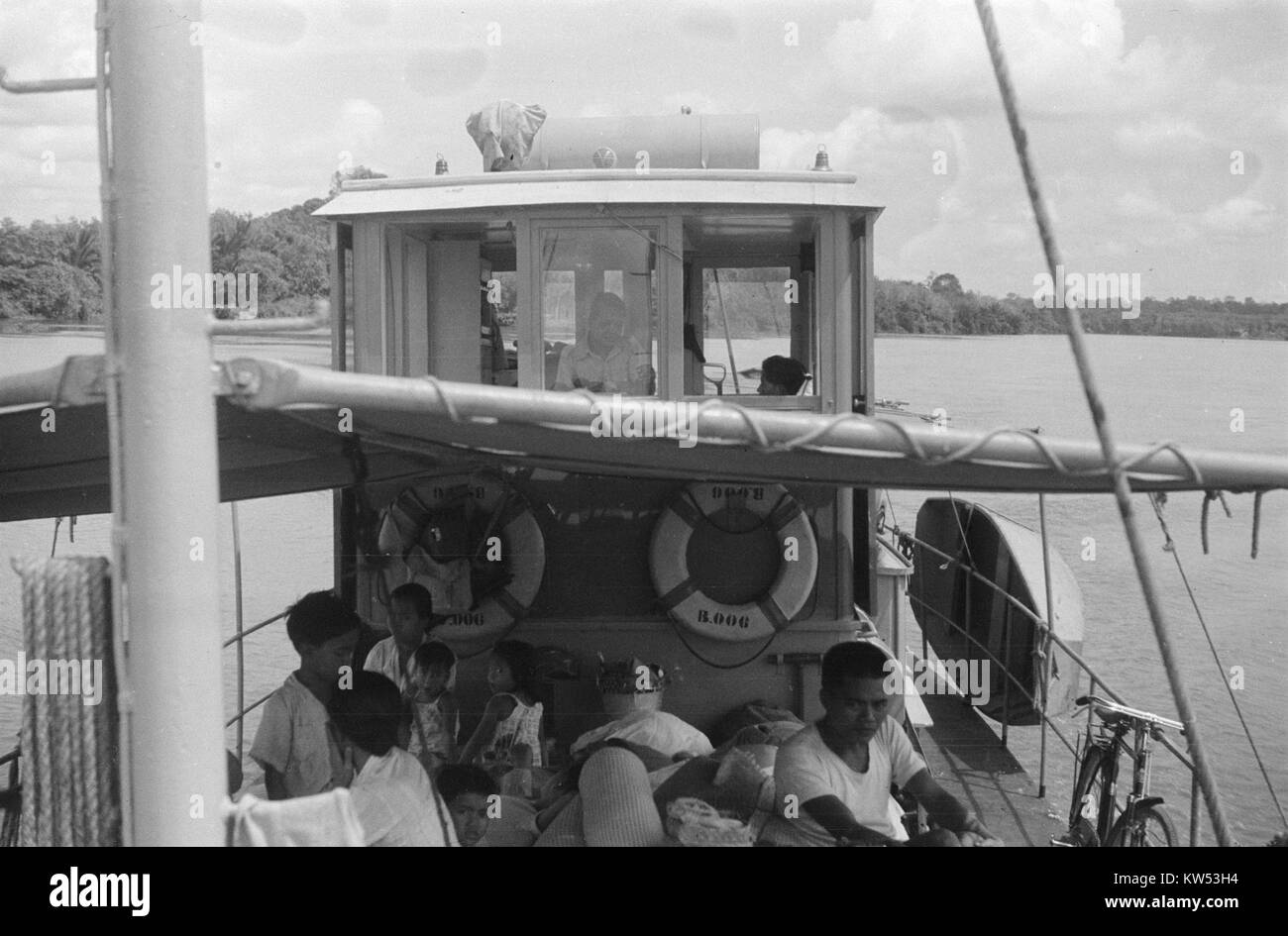 Binnenvaartschip op een rivier met opvarenden désigne un bateau de navigation intérieure sur une rivière avec des passagers à bord. L'image met en évidence un type de transport par eau utilisé historiquement ou actuellement pour le voyage ou le commerce. Banque D'Images