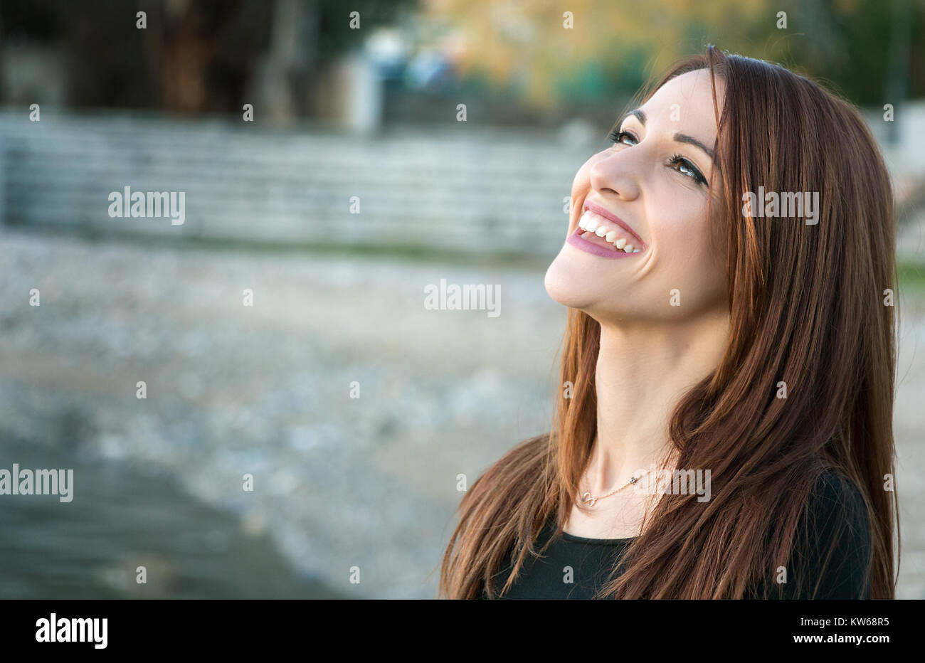 Portrait d'une femme rire spontanément, joyeuse, à l'extérieur, à la recherche. Banque D'Images