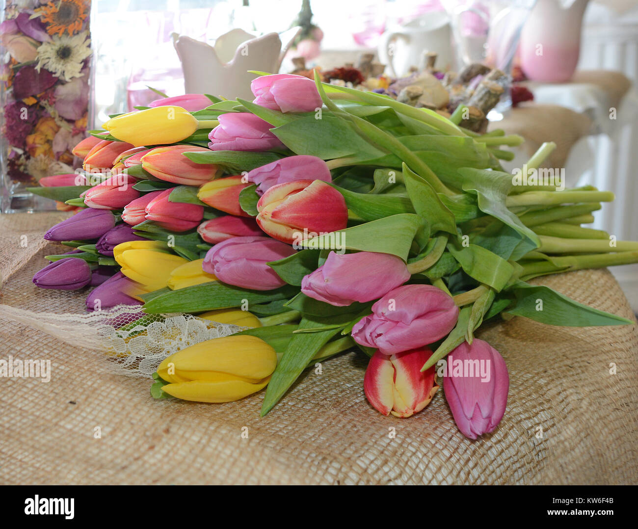 Brassée de tulipes colorées se coucha sur une table dans une chambre ensoleillée. Banque D'Images