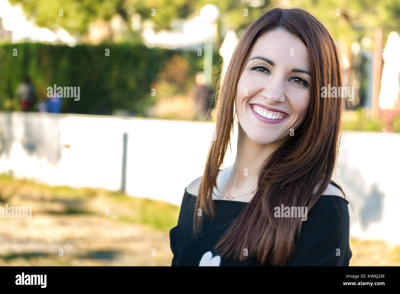 Portrait d'une femme lookiing à huis clos, souriant, joyeux, à l'extérieur. Banque D'Images
