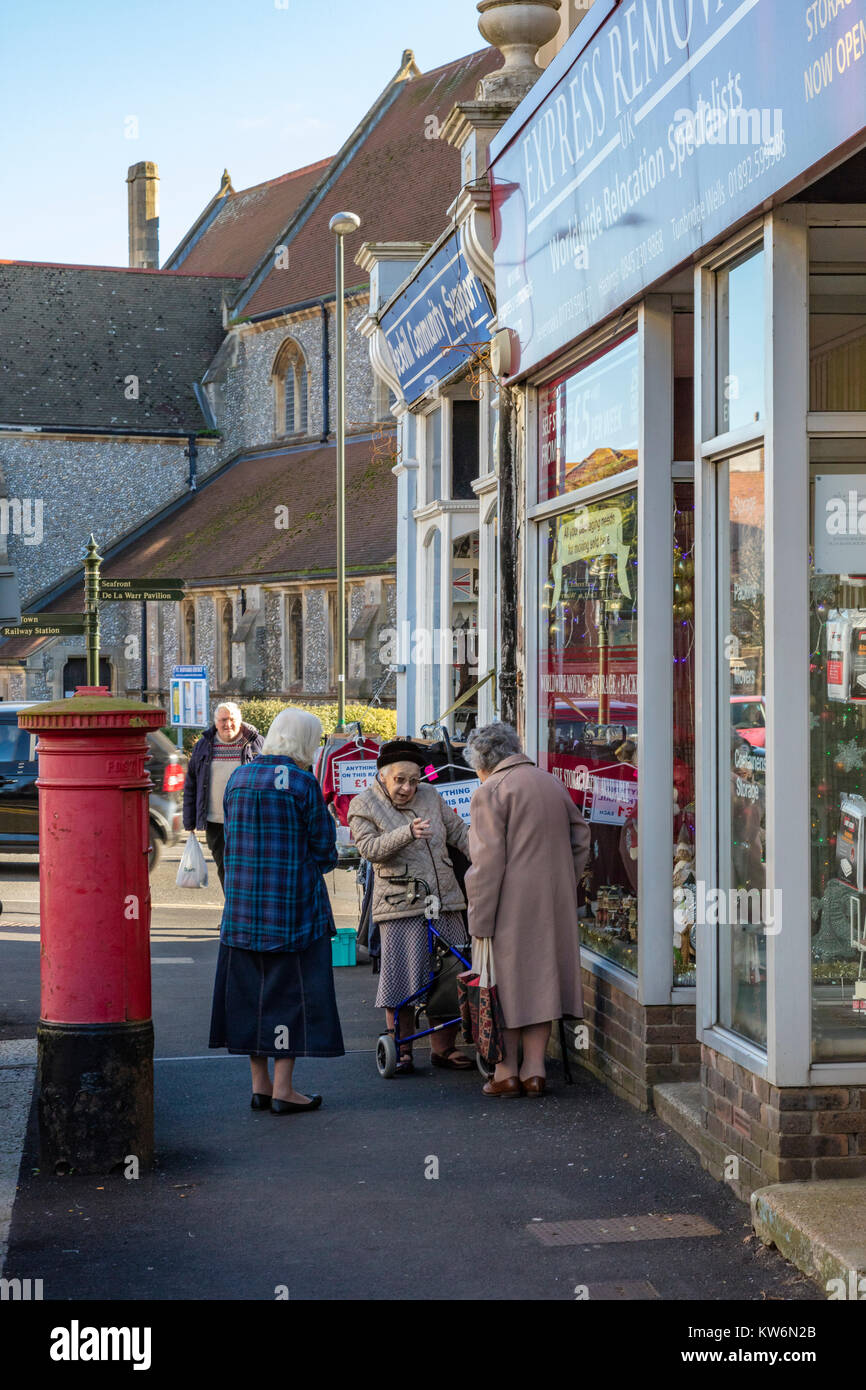Trois dames âgées ont une discussion animée à l'extérieur d'un magasin de charité en Bexhill on Sea, East Sussex, UK Banque D'Images