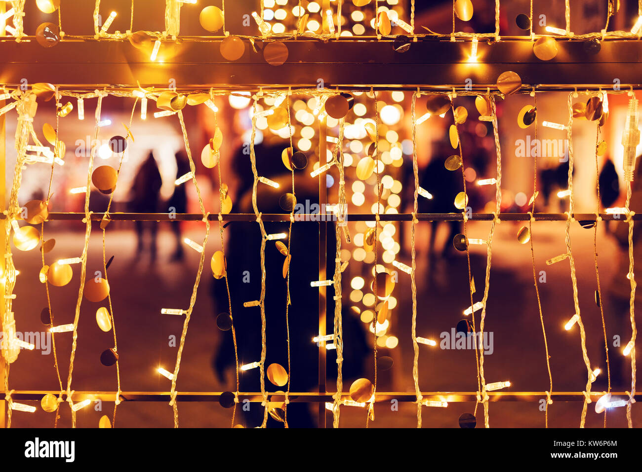 Silhouettes flou, foule de gens marchant sur la rue décorée durant la période des fêtes comme Noël et Nouvel an, la décoration lumineuse comme bokeh abstract ho Banque D'Images