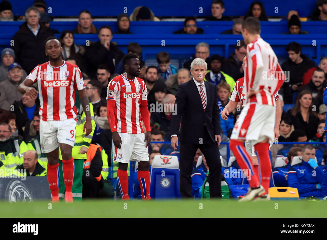 Stoke City manager Mark Hughes avec Saido Berahino (à gauche) et Mame Biram Diouf au cours de la Premier League match à Stamford Bridge, Londres. Banque D'Images