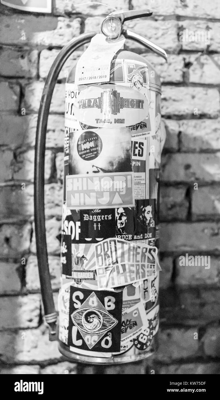 Le noir et blanc d'un sticker couverts extincteur dans un centre-ville Banque D'Images