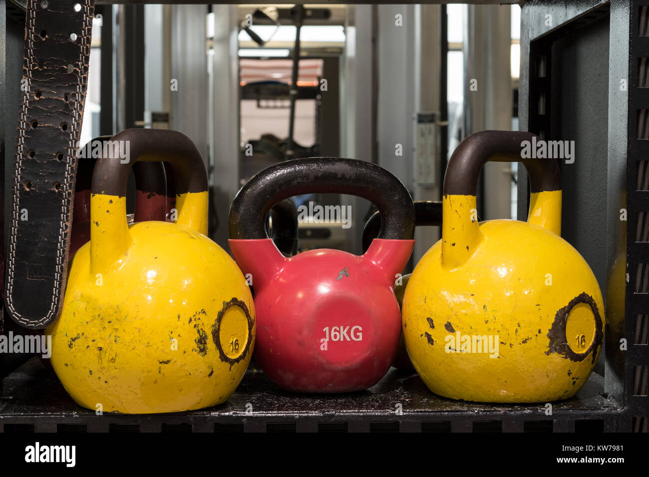 Jeu de colorful usé kettlebells sur une étagère métallique dans une salle de sport. Banque D'Images