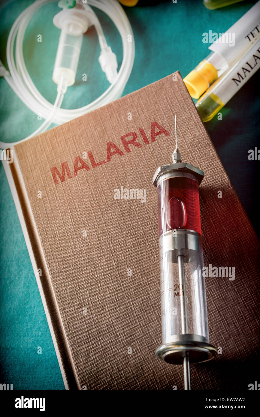 Seringue Vintage sur un livre de paludisme, concept médical Banque D'Images