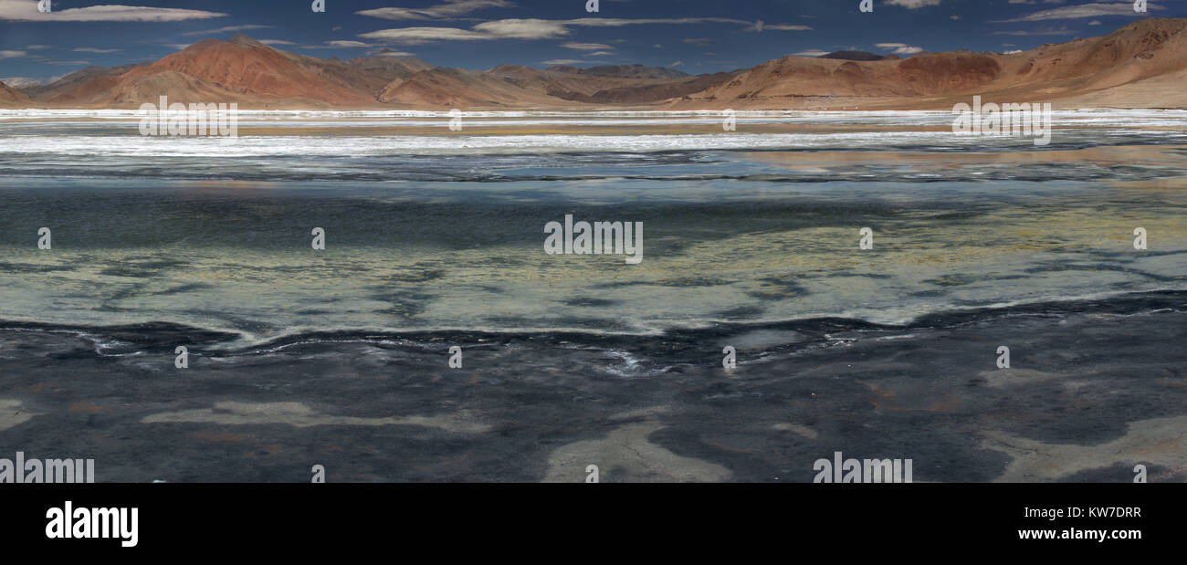 Blue transparent surface lisse du lac de montagne, de sable du littoral, à l'arrière-plan de Pink Mountain Range, l'Himalaya, au Tibet, pan photo Banque D'Images