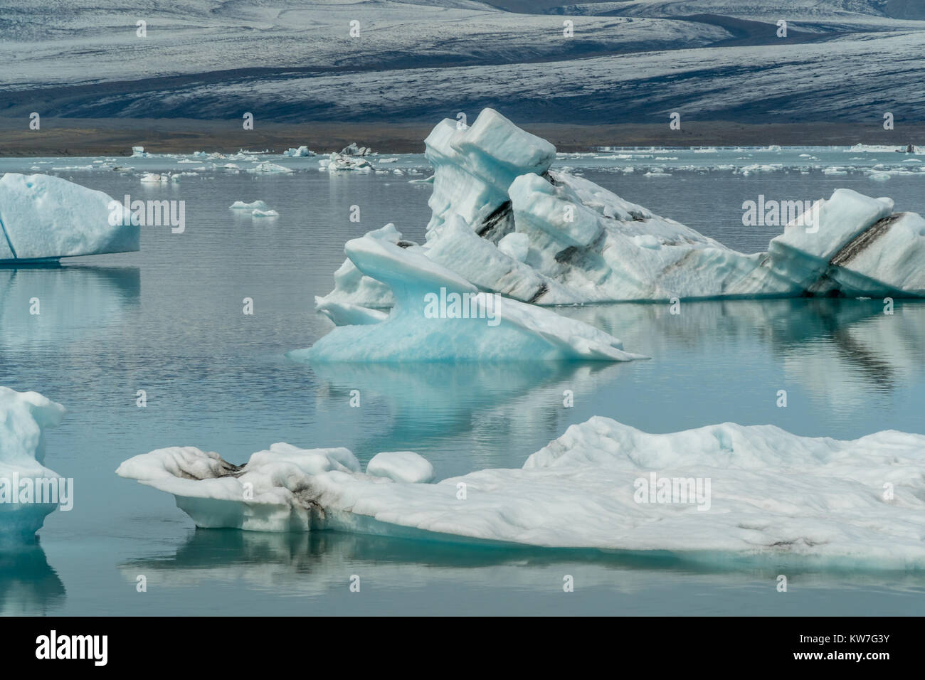 Glacier jökulsárlón lagoon bay avec des icebergs bleu flottant sur l'eau encore avec des réflexions, le sud de l'Islande en été. Banque D'Images