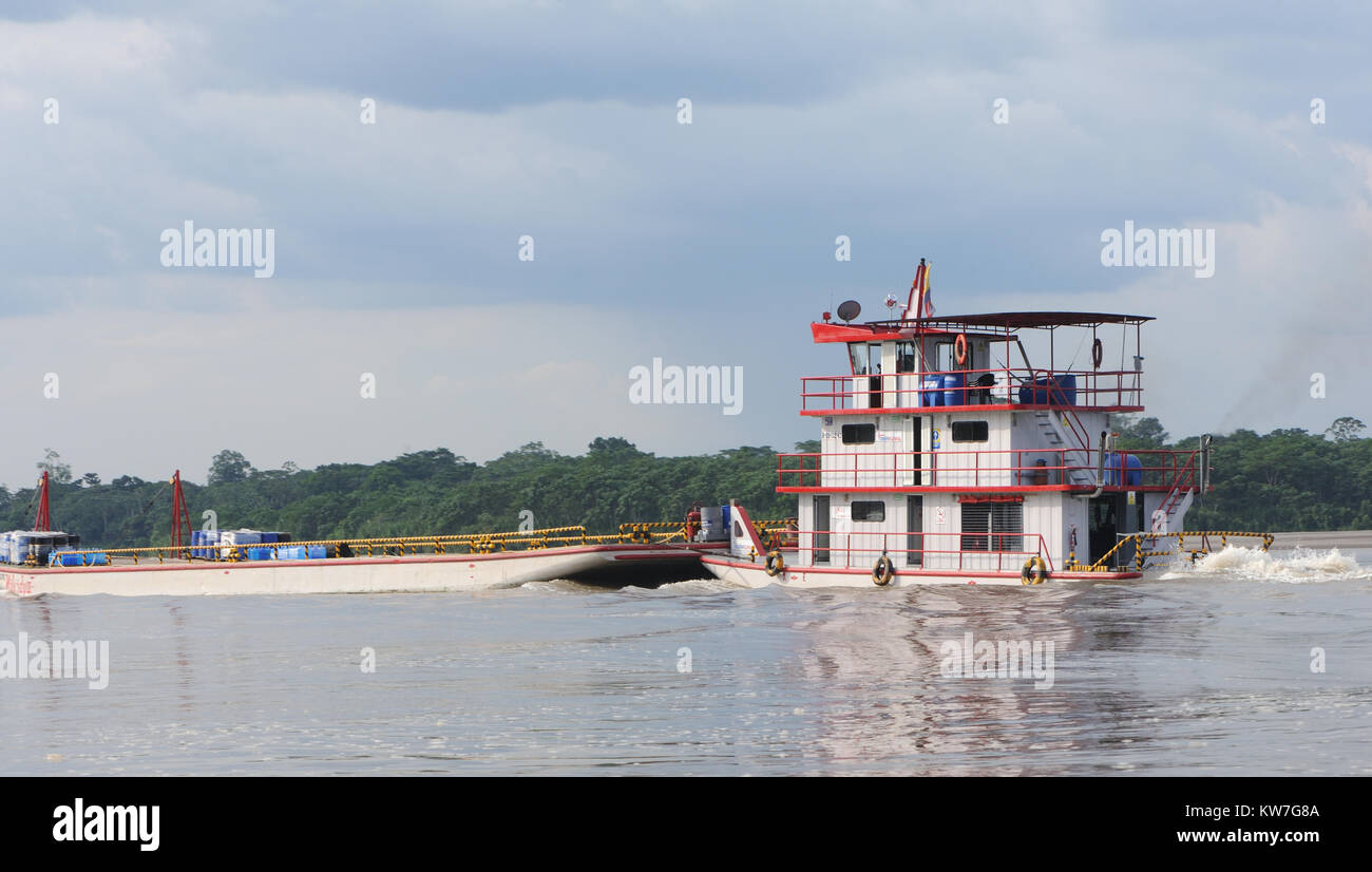 Un bateau à trois remorqueurs déchaîne une barge au-delà de la forêt tropicale sur la rivière Napo près de Coca ou de Puerto Francisco de Orellana. Coca, Puerto Francisco de Orellana Banque D'Images