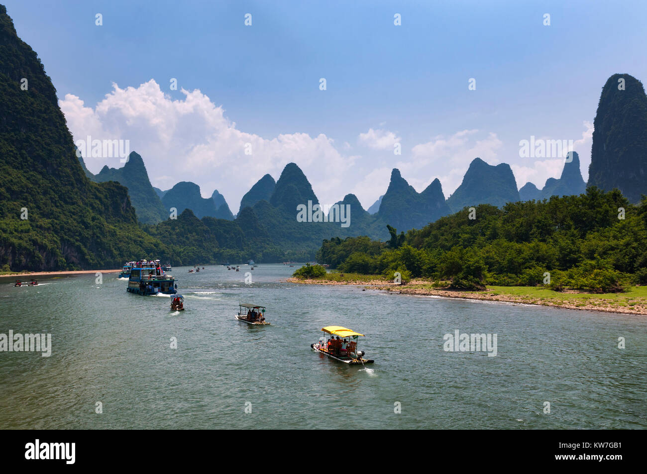 Yangshuo, Chine - 1 août 2012 : Bateaux de touristes en croisière dans la rivière Li avec les îles de calcaire dans le fond près de Yangshuo en Chine, Banque D'Images