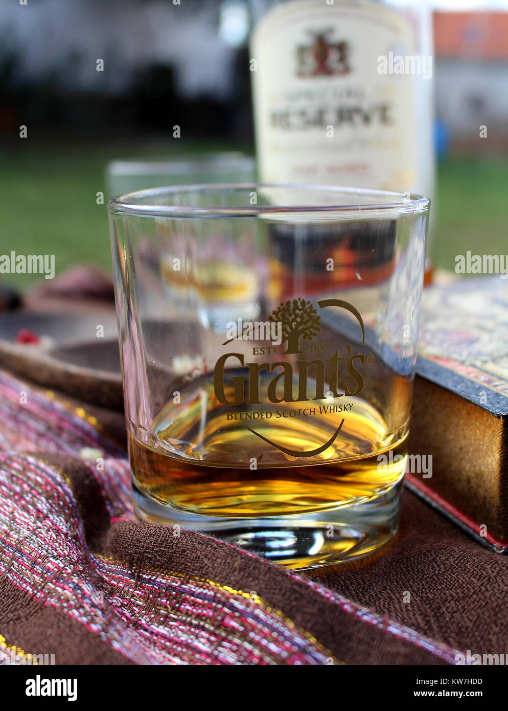 Temps pour prendre un verre - verre de whisky sur une table de jardin, célébration Banque D'Images