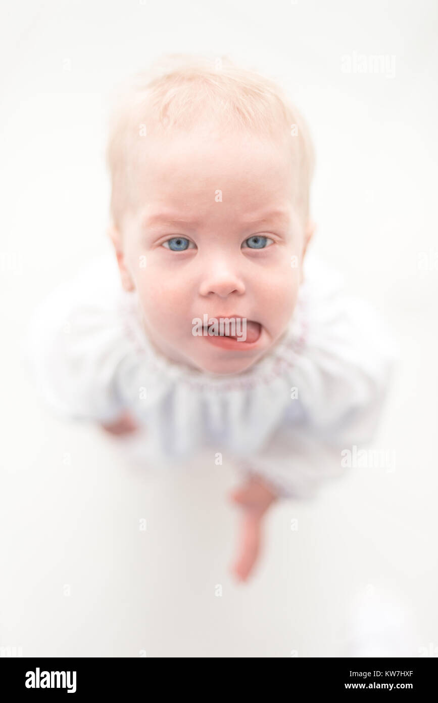 Cute baby girl toddler est montrant sa langue Banque D'Images