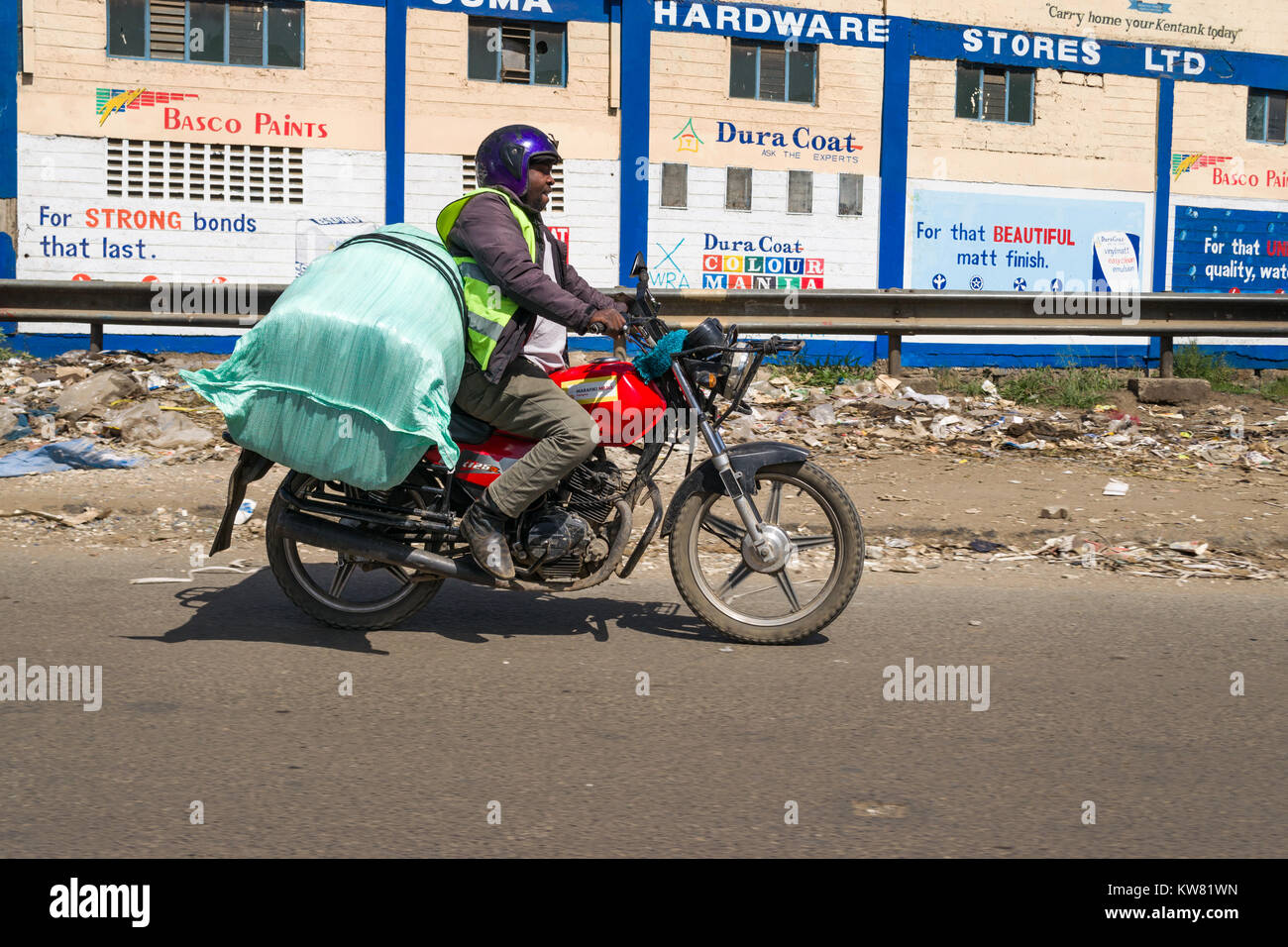 Un boda boda mâle un motard portant un grand sac à l'arrière de sa moto, Nairobi, Kenya, Afrique de l'Est Banque D'Images