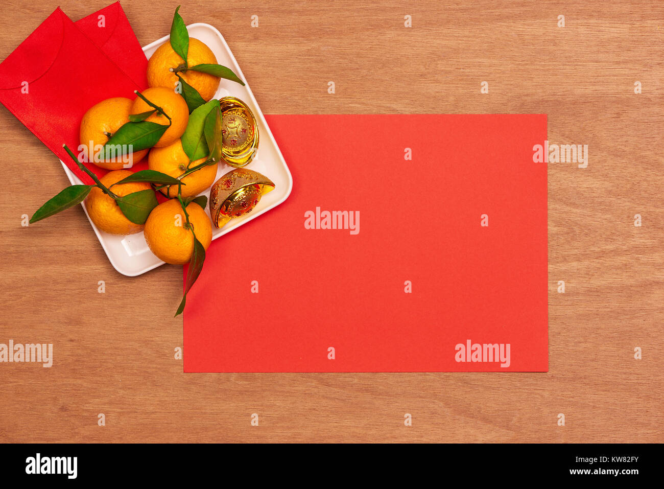 Haut afficher les accessoires le festival du Nouvel an chinois.décorations,orange,feuilles,panier Bois de prunier,paquet rouge sur fond rouge. Banque D'Images