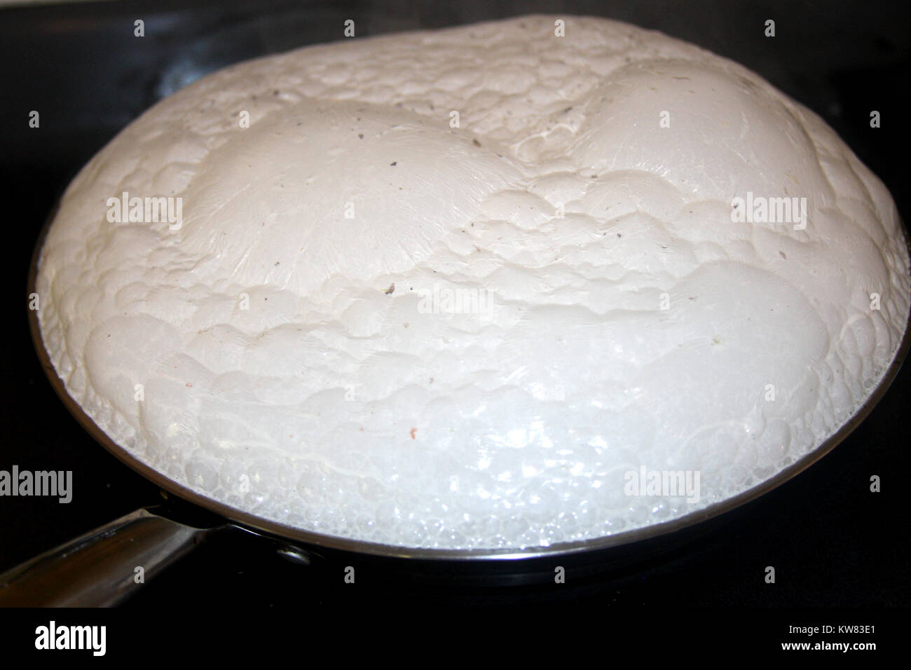 Sauce blanche à base de lait dans la casserole bouillante Banque D'Images