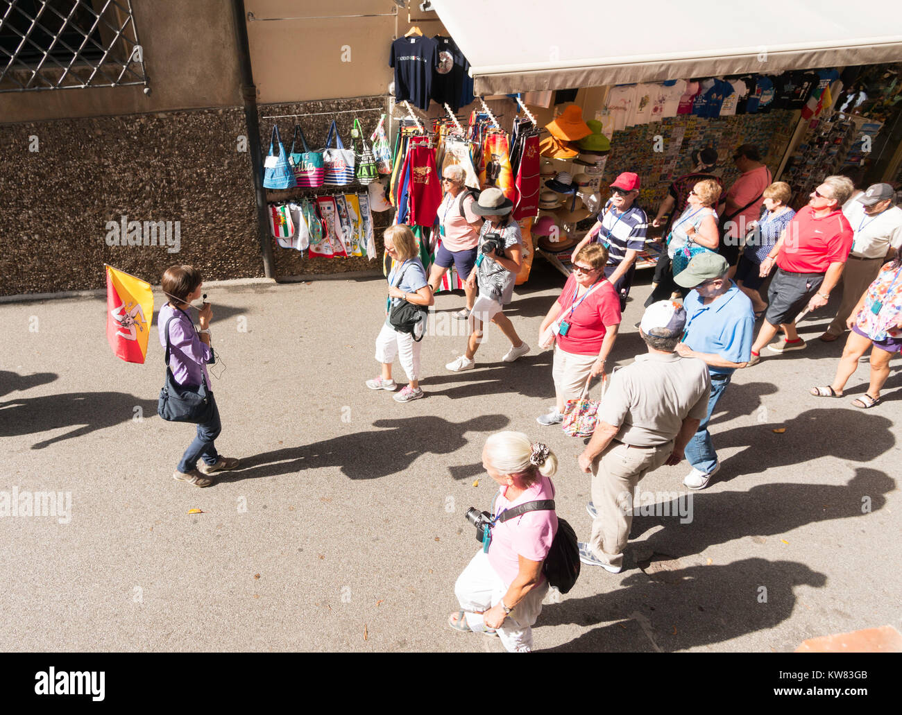 Un guide à la tête d'un groupe de touristes à travers la vieille ville de Taormina, Sicile, Europe Banque D'Images