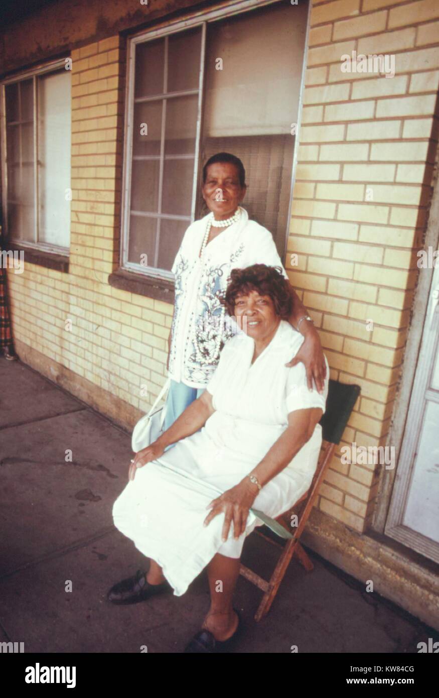 Deux femmes noires, l'un assis sur une chaise comme l'autre se tient à côté d'elle, sur un des balcons de la Robert Taylor Homes, à faible revenu tours d'appartements à Chicago, Illinois, 1973. Image courtoisie John White/US National Archives. L'image de courtoisie des Archives nationales. Banque D'Images