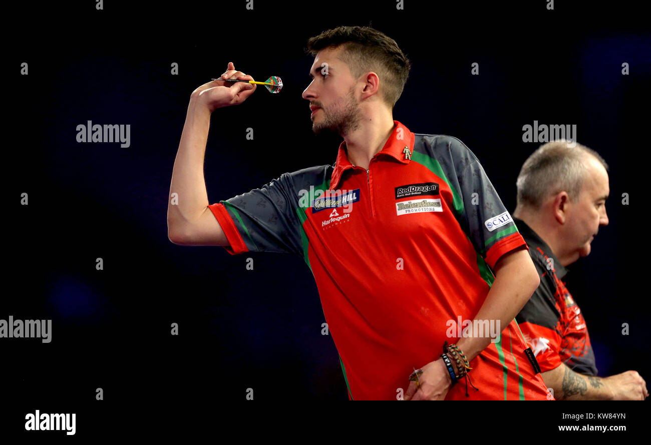 Jamie Lewis et Phil Taylor en action au cours de la journée quatorze William Hill World Darts Championship à Alexandra Palace, Londres. Banque D'Images