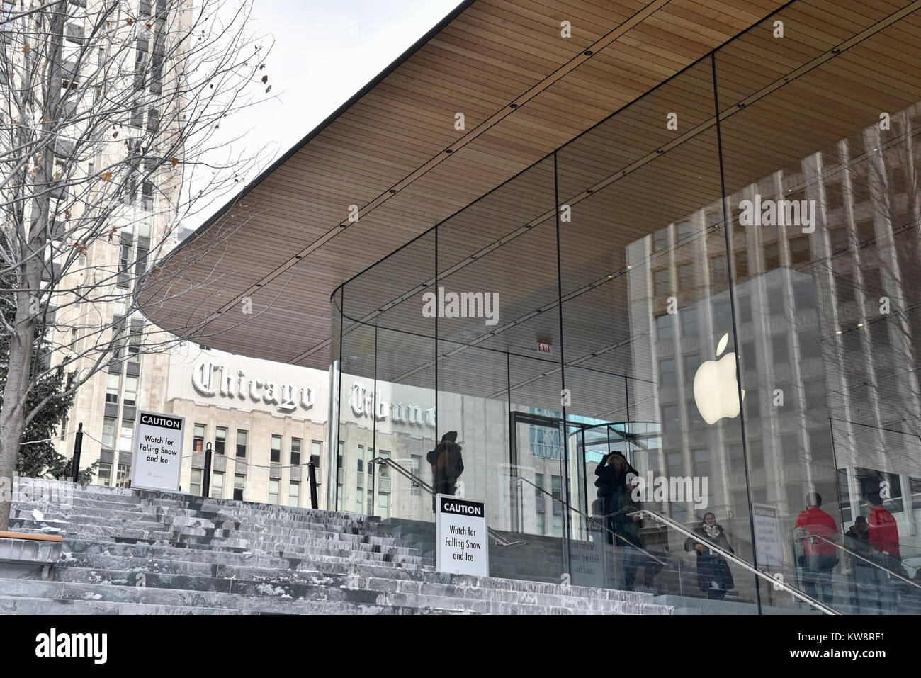 Chicago, USA. 31 décembre 2017. Des panneaux de mise en garde les passants par des chutes de glace sont à l'écran autour de la nouvelle figure de proue des Apple Store, North Michigan Avenue, à côté de la rivière Chicago. Le bâtiment, conçu par les architectes britanniques Foster +Partners, possède un toit en forme le couvercle d'un portable Apple et s'affiche à l'absence visible des gouttières. Les glaçons qui se sont formées dans l'actuelle des températures sous zéro se sont écrasés au sol ci-dessous mettant en danger le public et le magasin est actuellement confronté à des critiques de la part des sections locales à élaborer une solution. Crédit : Stephen Chung / Alamy Live News Banque D'Images