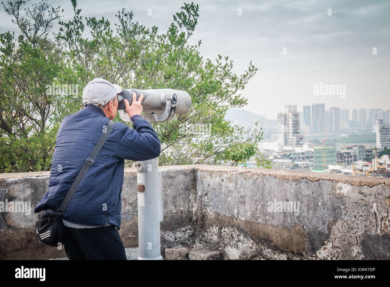 Vieil homme en utilisant le télescope à Macao Banque D'Images