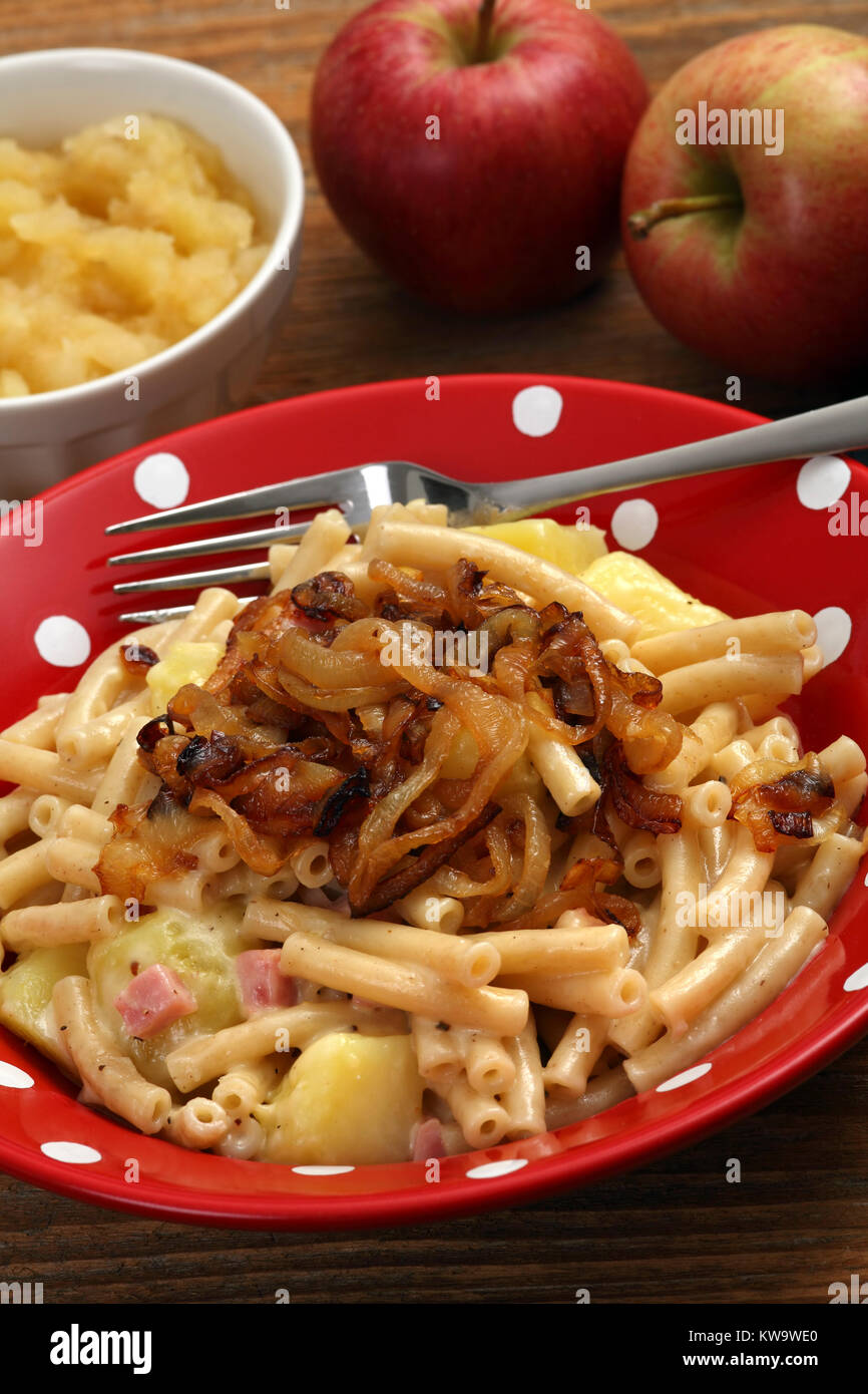 Photo d'un bol d'alplermagronen, alpin ou farmer's macaroni, un repas traditionnel suisse faite avec des nouilles, pommes de terre, fromage, oignons et servi avec un Banque D'Images