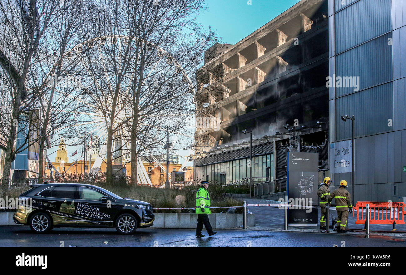 Les équipes d'incendie à l'plusieurs étages près de l'Echo Arena de Liverpool, après la nuit dernière, l'incendie qui a détruit des centaines de voitures. Banque D'Images