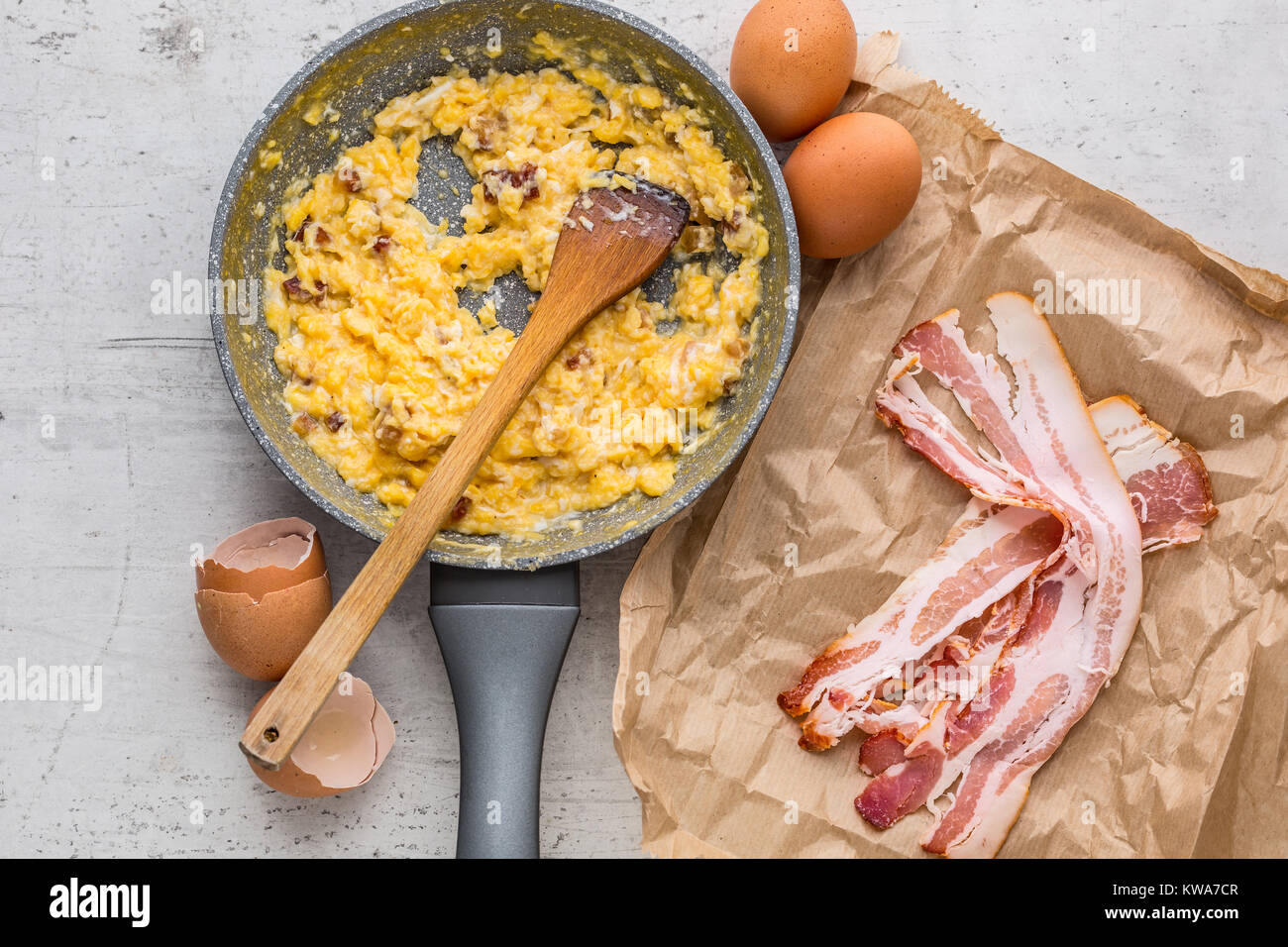 Du jambon et des œufs. Oeufs brouillés avec bacon dans pan en céramique. Banque D'Images