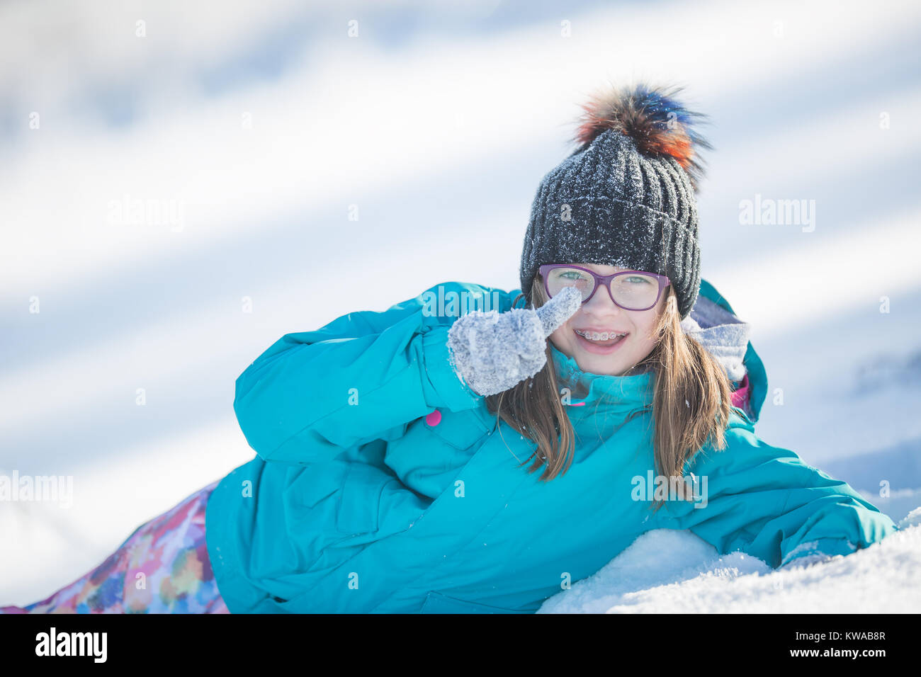 Happy young girl in Pre-Teen vêtements chauds à jouer avec la neige. Banque D'Images
