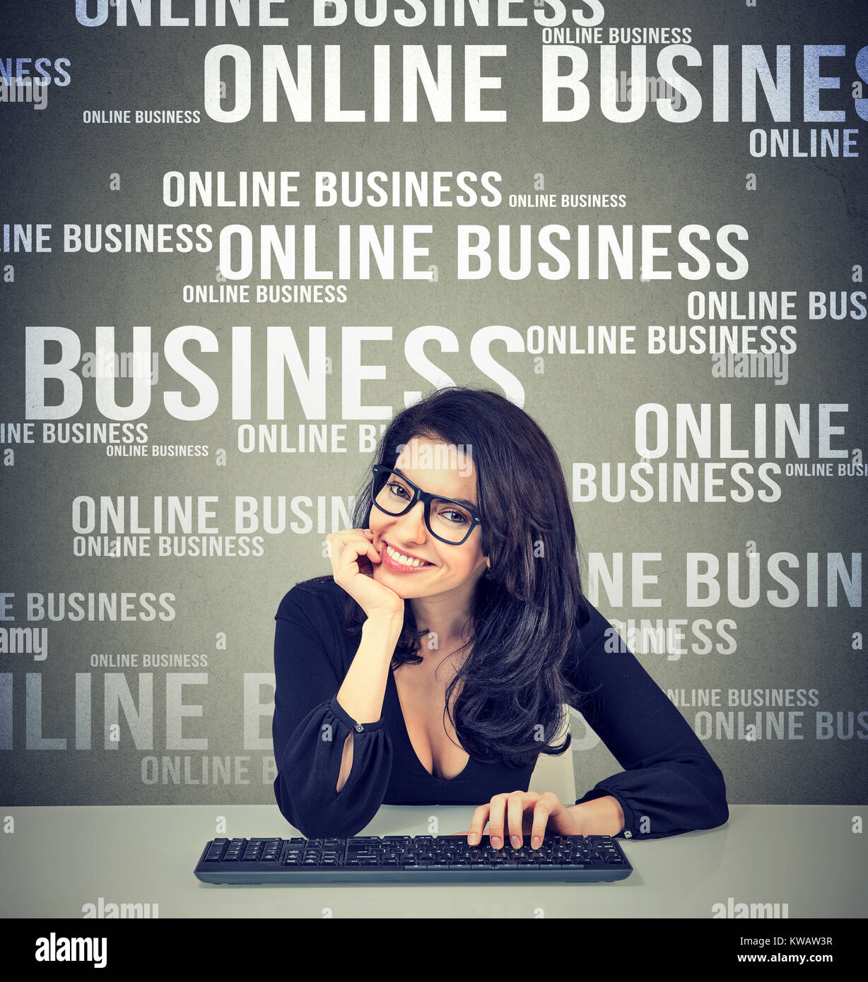 Belle brunette élégant avec clavier réussir dans les affaires en ligne smiling at camera. Banque D'Images