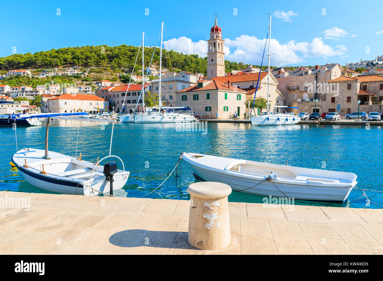 Bateaux de pêche au port de Supetar avec belle église en arrière-plan, l'île de Brac, Croatie Banque D'Images