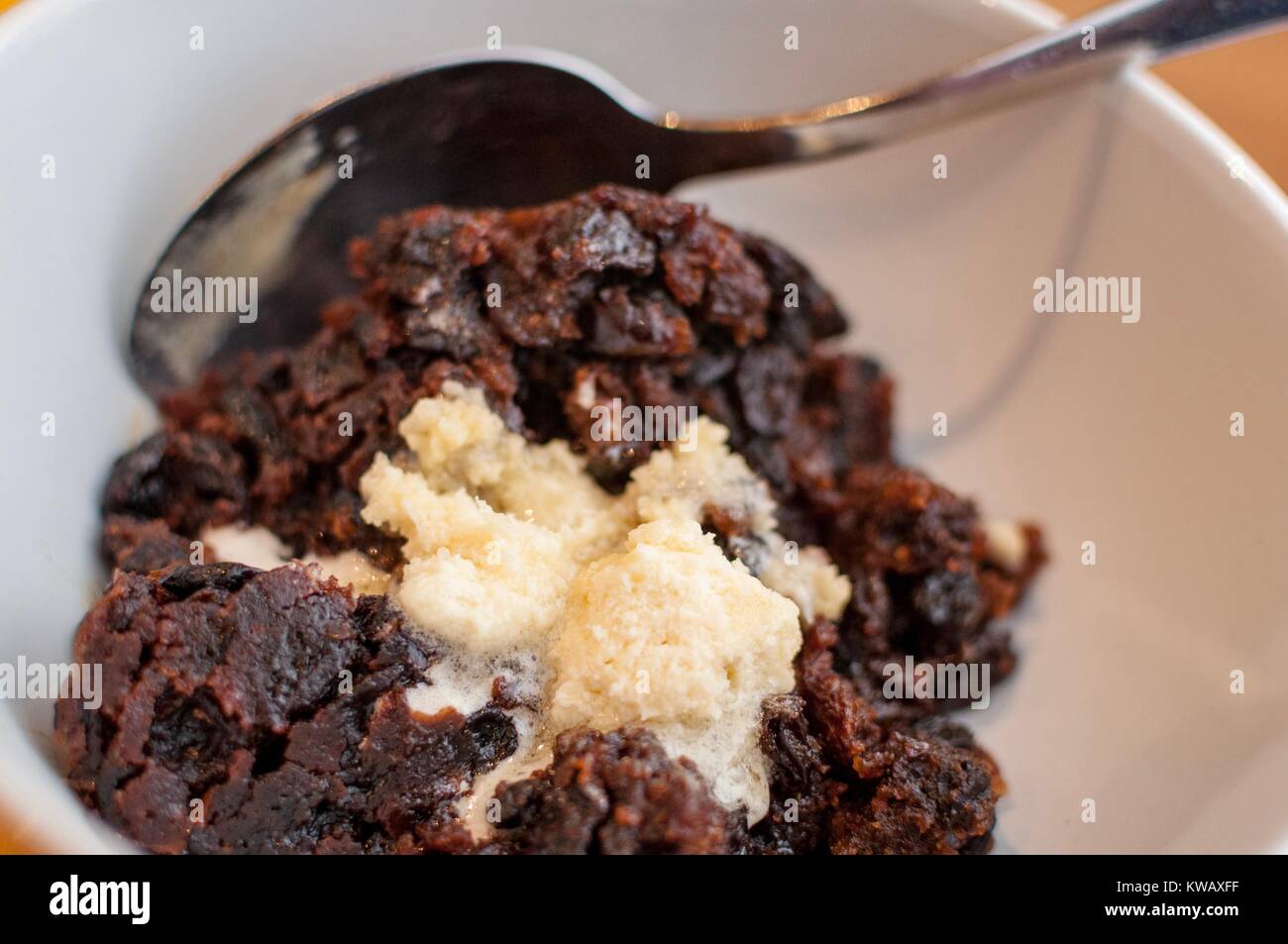 Une partie de pudding de Noël avec un peu de beurre dans un bol de brandy Banque D'Images