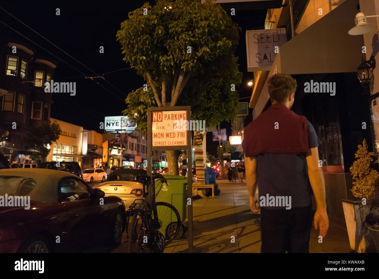 Un homme qui a un pull marron drapé sur ses épaules se tient sur le trottoir, San Francisco, Californie, le 8 octobre 2016. Banque D'Images