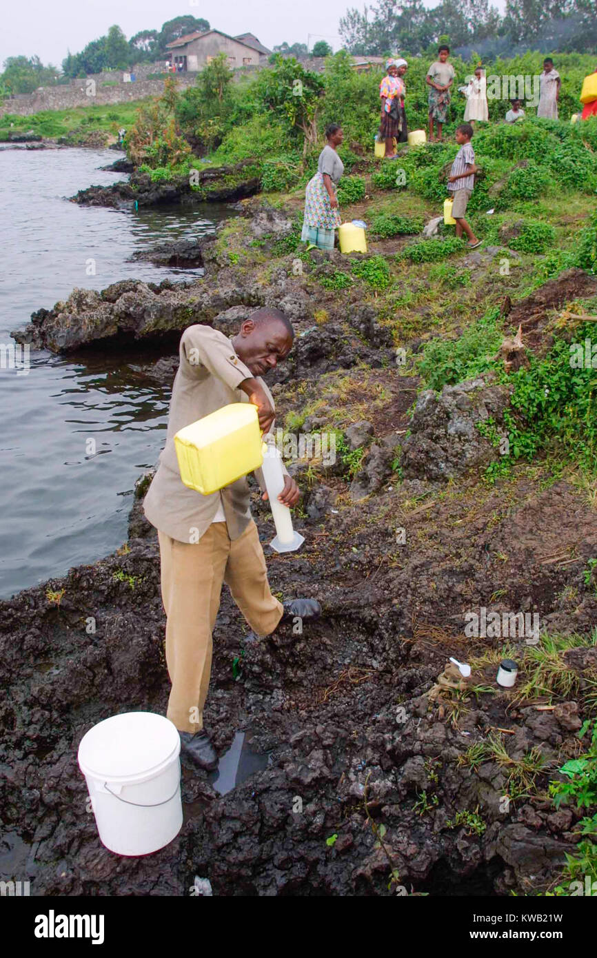 Un Medicin Sans travailleur frontalier se mélange d'une solution de chlore avec lesquels il va stériliser que les gens ont pris l'eau du lac Kivu. Banque D'Images