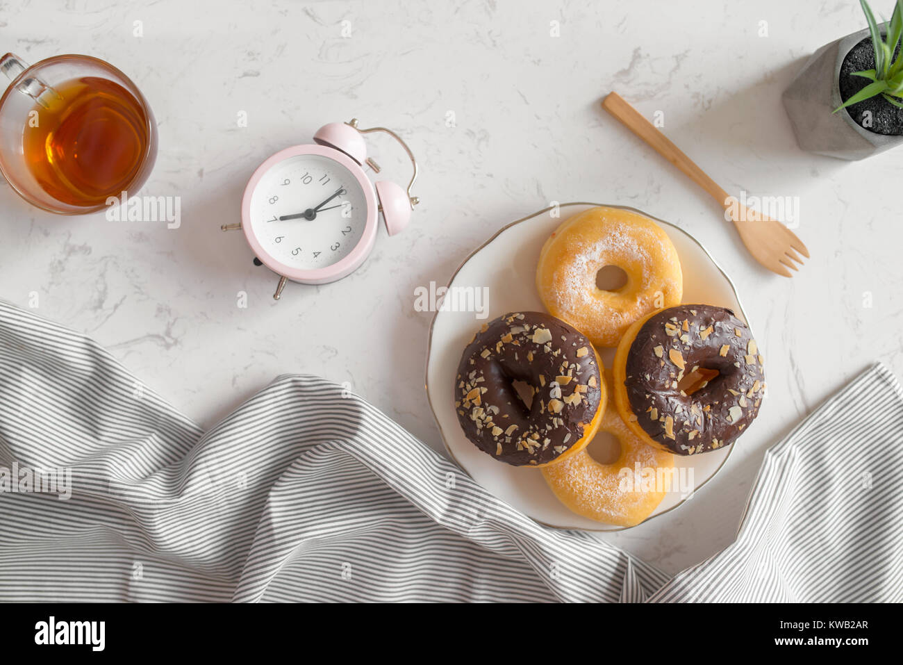 Vue de dessus avec la tasse de café et beignes réveil sur table. Le petit déjeuner du matin. Banque D'Images